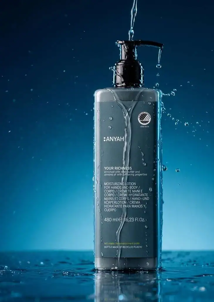Anyah pump bottle with water droplets against a blue background