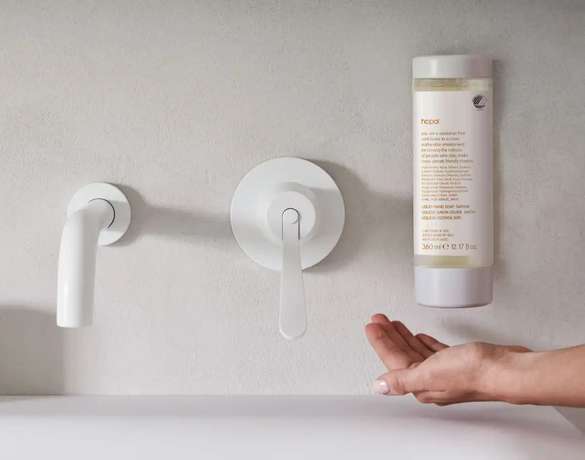 Wall-mounted Hopal Squeezable dispenser beside a white tap